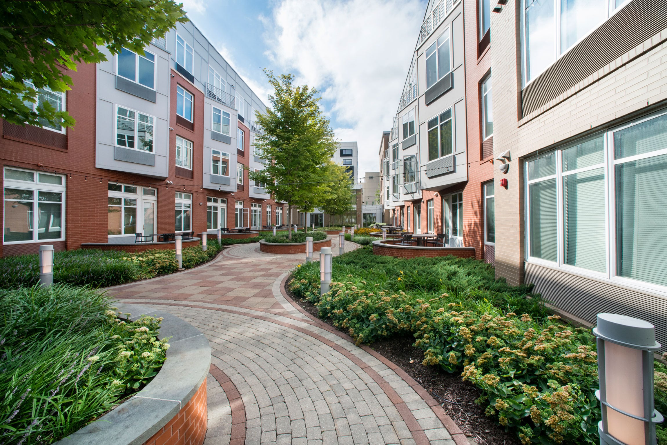 stone walking path in apartment courtyard with trees and greenery