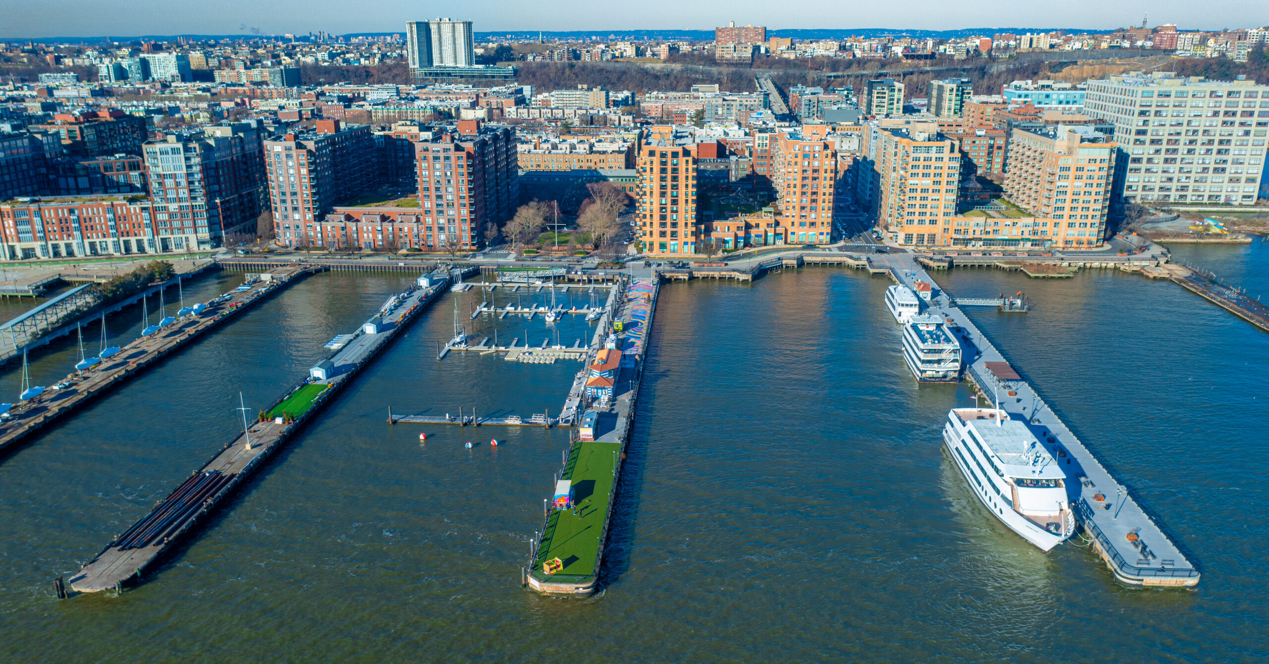 Aerial view of Hoboken’s waterfront marina and residential buildings along the Hudson River, showcasing the city’s blend of modern living and historic charm.